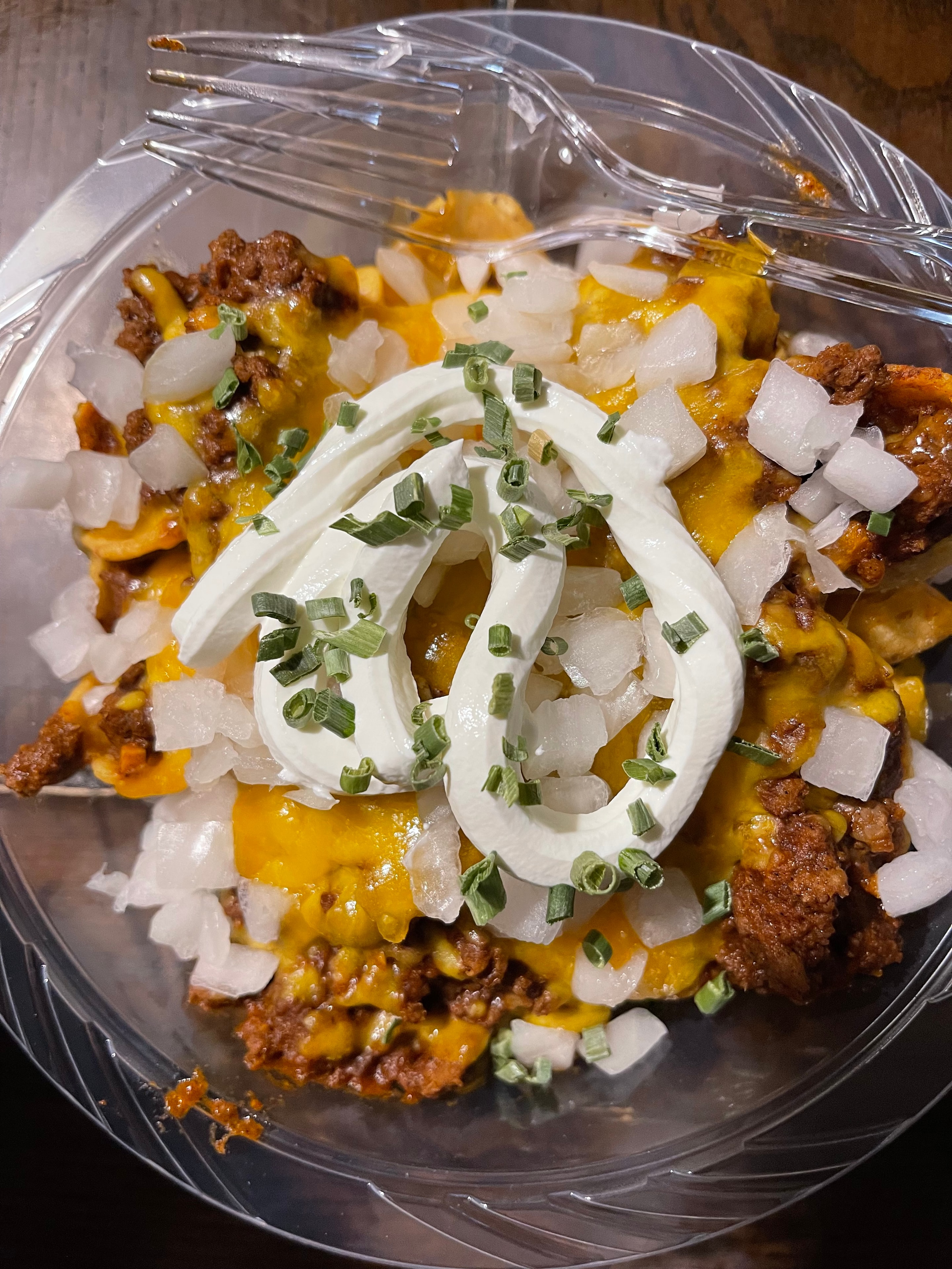 Loaded waffle fries with cheese, meat, sour cream and green onions